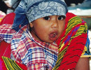 9 guatemalan child getting a ride through the market place